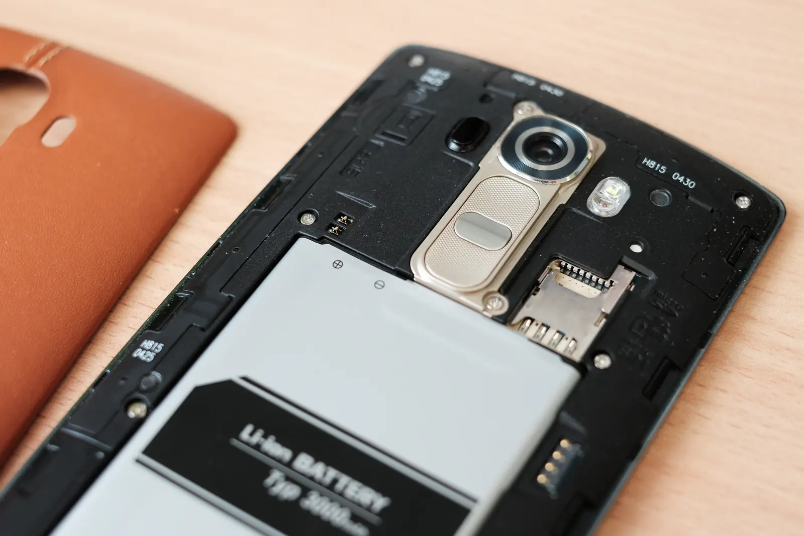 LG G4 H815 打开皮革后盖的原近照，相机、按键、卡槽与电池