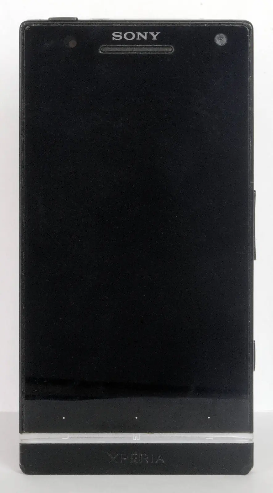 黑色 Xperia S 实物正面，屏幕关闭，透明条及按键点可见