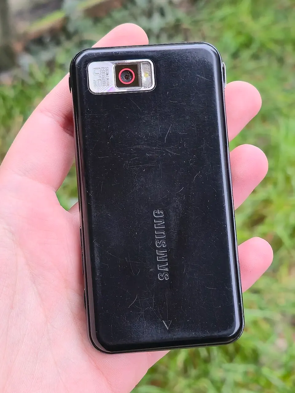 黑色 Samsung SGH-i900 Omnia 实物背面，保留旧机磨损