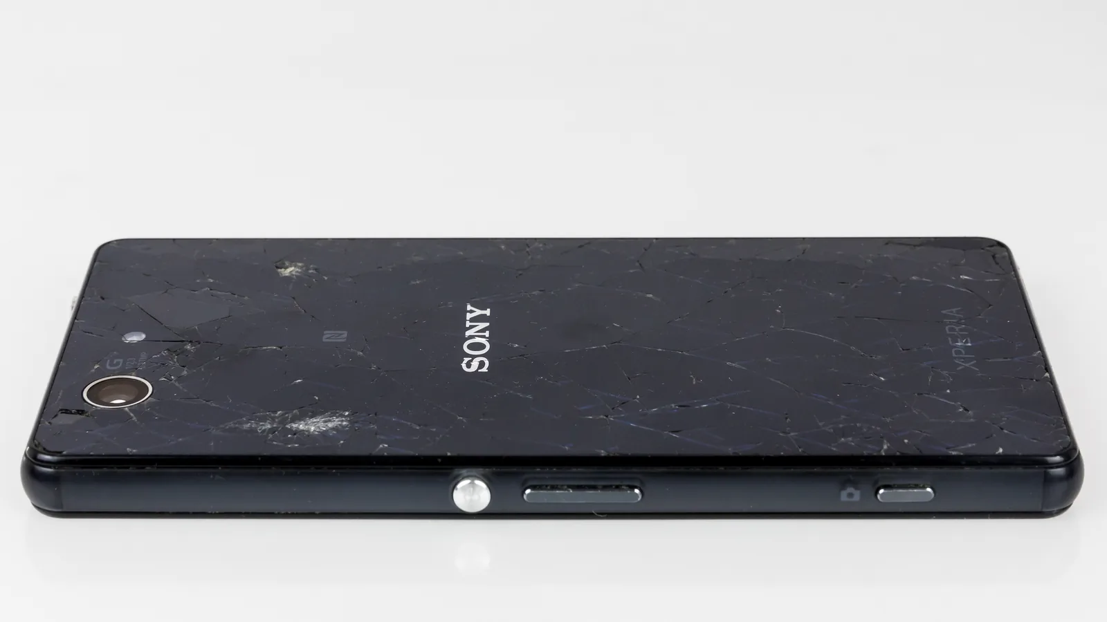 Xperia Z3 Compact cracked glass rear and right-side keys, complete source frame and damage retained